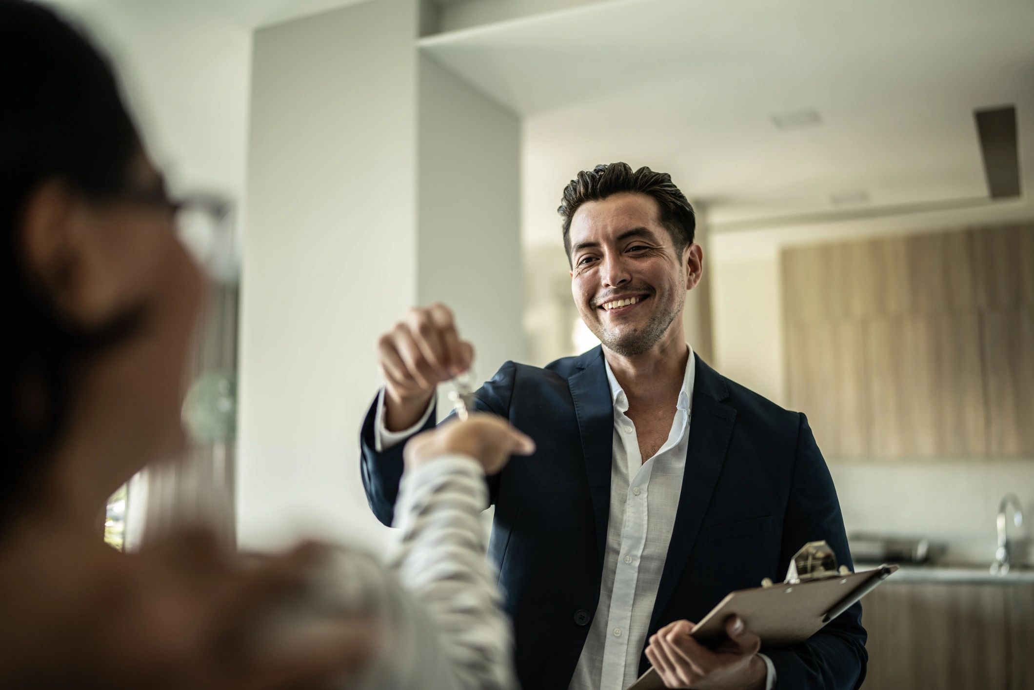 Real estate agent handing keys to a home buyer
